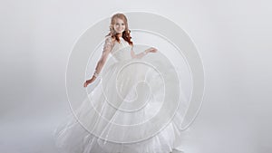 Lovely young woman bride in a lavish wedding dress. Light background..
