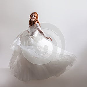 Lovely young woman bride in a lavish wedding dress. Light background.