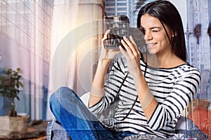 Lovely young woman holding an instant photo camera