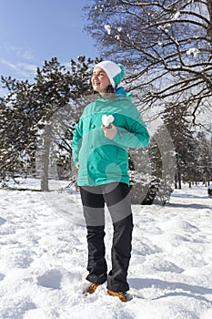 Lovely young woman showing snow heart