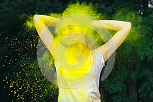 Lovely young woman standing in a cloud of color paint photo