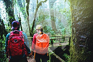 Lover asian man and asian women travel nature. Nature Study in the rain forest at Chiangmai in Thailand