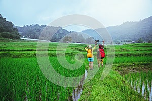 Lover asian men asian women travel nature Travel relax Walking a photo on the rice field in rainy season in Chiang Mai, Thailand