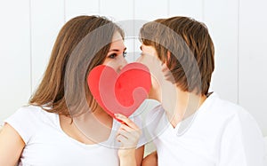 Lover couple kissing with a red heart in bed