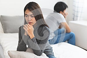 Lover couple relationship problems. Sad young wife sitting on the bed back to back from husband after argument