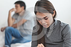 Lover couple relationship problems. Sad young wife sitting on the bed back to back from husband after argument