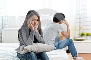 Lover couple relationship problems. Sad young wife sitting on the bed back to back from husband after argument