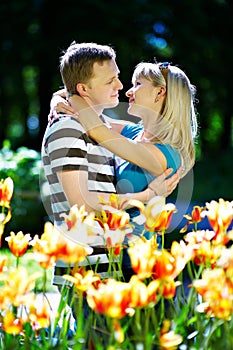 Lover man and girl among red yellow flowers