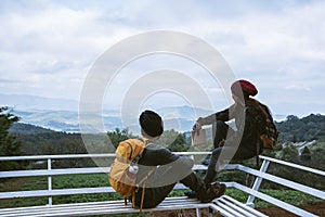 Lover sitting relaxing at the natural mountain viewpoint and writing a record of winter travel