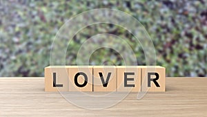 Lover word Wooden cubes on table over background leaves green HD, mock up, template, love for one`s partner, good friends, no war