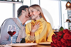 Lovers at beginning of love story - Handsome man whispers in pretty woman ear