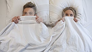 Lovers caught in bed by parents, embarrassed and frightened, looking shocked photo