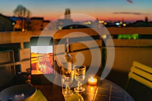 Lovers celebrate romantic dinner on the terrace with the light of the candle and wine on the confined of the quarantine.