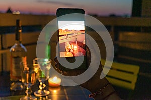 Lovers celebrate romantic dinner on the terrace with the light of the candle and wine on the confined of the quarantine.