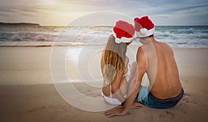 Lovers couple in santa hats at tropical sandy beach