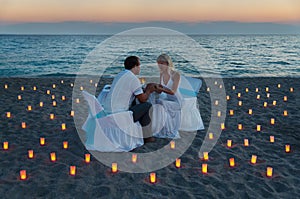 Lovers couple share a romantic dinner on sea beach