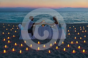 Lovers couple share a romantic dinner on sea beach