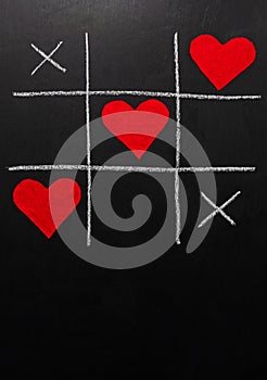Lovers day concept. tic-tac-toe game where instead of zeroes are red hearts. on a black background. vertical orientation