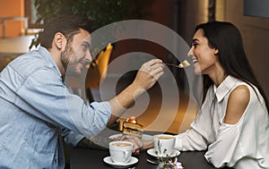 Lovers Feeding Each Other Having Date In Coffee Shop