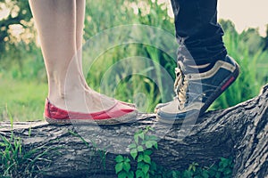 Lovers` feet on a tree branch