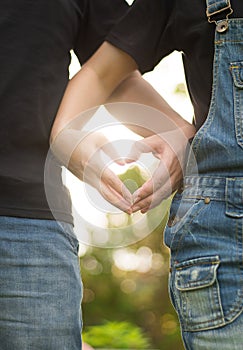 Lovers hands makeing heart shape together by hand