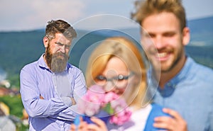 Lovers hugs outdoor flirt romance relations. Couple in love dating while jealous bearded man watching wife cheating him