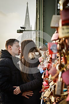 Lovers kissing on a bridge full with locks