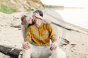 A lovers is kissing. Young couple is having fun and hugging on the beach. Beautiful girl embrace her boyfriend from back