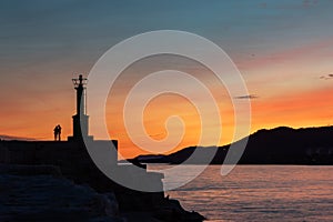 Lovers at the lighthouse at sunset