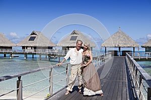 Lovers, man and woman on a wooden path at the sea, tropics