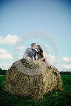 Lovers resting in a field near haystacks