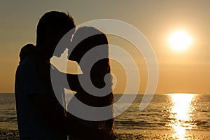 Lovers silhouette passionately close to each other at sunset