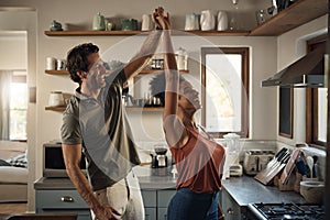He loves dancing with his queen. an affectionate young couple dancing together in their kitchen at home.