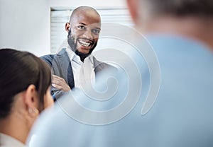 He loves hearing all the positive feedback from his team. Shot of a young businessman having a meeting with his