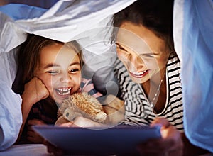 She loves her stories. Cropped shot of an attractive young pregnant woman reading her daughter a bedtime story on a