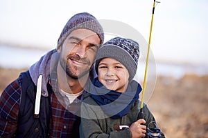 He loves his son. Portrait of a loving father and son fishing by the sea.