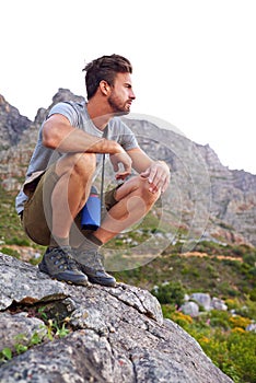 He loves the outdoors. a handsome young man enjoying the view while hiking.