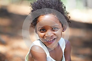 She loves playing in the woods. Portrait of an adorable little girl smiling at the camera while enjoying a day outdoors.