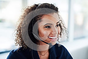 She loves working in this call center. High angle shot of an attractive young female call center agent working in her