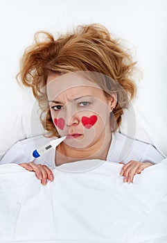 Lovesick woman with thermometer in bed