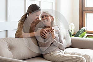 Loving adult daughter hugging older mother, enjoying tender moment