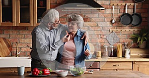 Loving affectionate mature couple cooking at home.