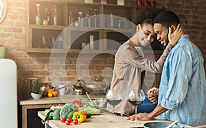 Loving african-american couple drinking wine in kitchen.