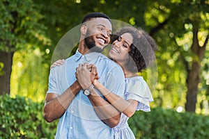 Loving african-american couple hugging in summer park