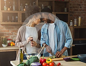 Loving african-american couple preparing dinner in kitchen