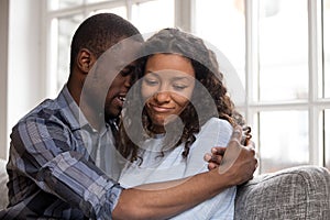 Loving African American husband embracing wife after quarrel