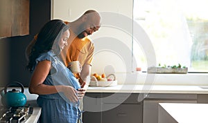 Loving African American Husband With Pregnant Wife At Home In Kitchen Together