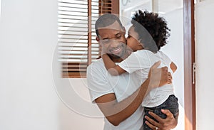 Loving African American Little Boy kissing his Father at home. Happy of Black family. African Dad and Son Hugging