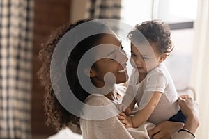 Loving African American mother cuddle with baby daughter