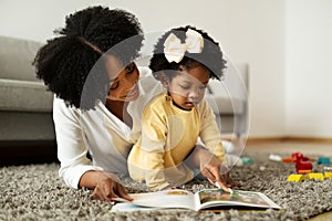 Loving african american mother reading book with her child